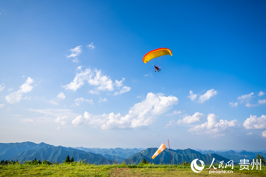 游客在野玉海飛行營(yíng)地乘動(dòng)力滑翔傘體驗(yàn)云端觀景。人民網(wǎng)記者 涂敏攝