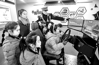 山東省榮成市公安局道路交通安全宣傳教育基地，交警帶領(lǐng)小學(xué)生現(xiàn)場體驗?zāi)M駕駛。新華社發(fā)