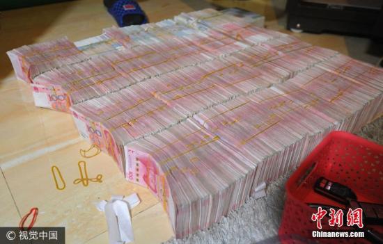 廣西南寧警方8月21日通報(bào)，當(dāng)?shù)亟粘晒善粕姘附痤~15.19億元人民幣的特大傳銷案件。圖為當(dāng)場繳獲的成捆現(xiàn)金。圖片來源：視覺中國